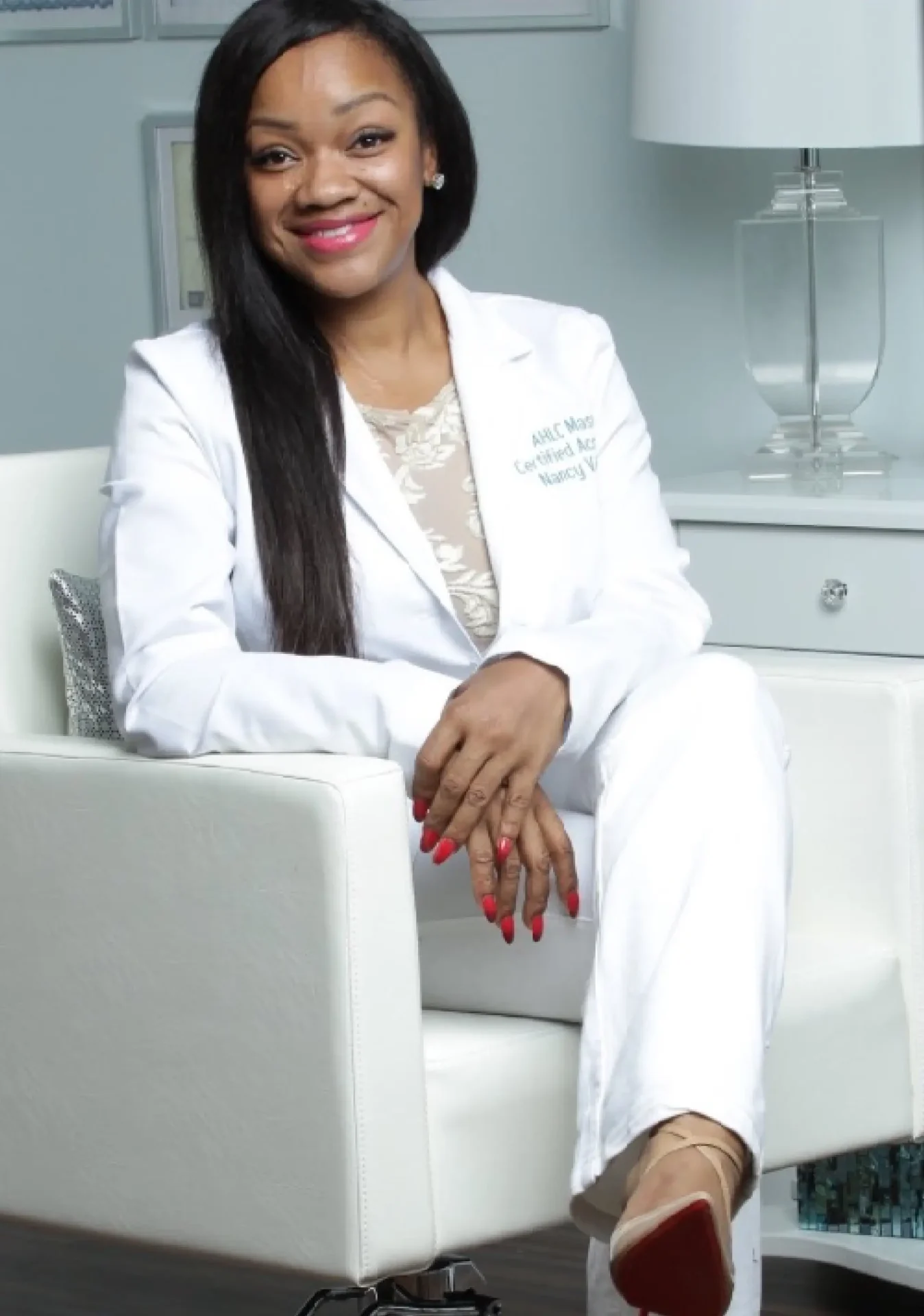 A woman in white suit sitting on chair.