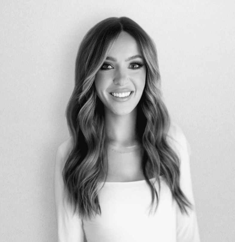 Smiling woman with long wavy hair.